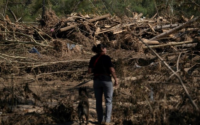 Cheryl Phillips e seu cão, Kite, buscam cadáveres após a passagem do furacão Helene por Burnsville, Carolina do Norte, em 5 de outubro de 2024