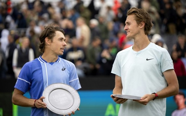 O australiano Alex de Minaur (esq.) comemora com o troféu após vencer o americano Sebastian Korda na final do torneio de Hertogenbosch, na Holanda, em 16 de junho de 2024.