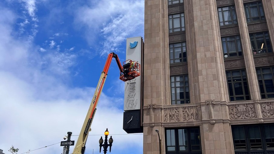 Guindaste retirando antiga logo do Twitter de prédio