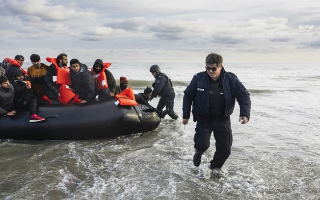 Policiais franceses rasgam um bote para evitar que migrantes atravessem o Canal da Mancha até o Reino Unido, na praia de Gravelines, perto de Dunquerque, norte da França, em 26 de abril de 2024