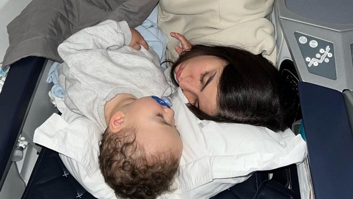 Bianca Andrade e o filho Cris em cabine de avião.