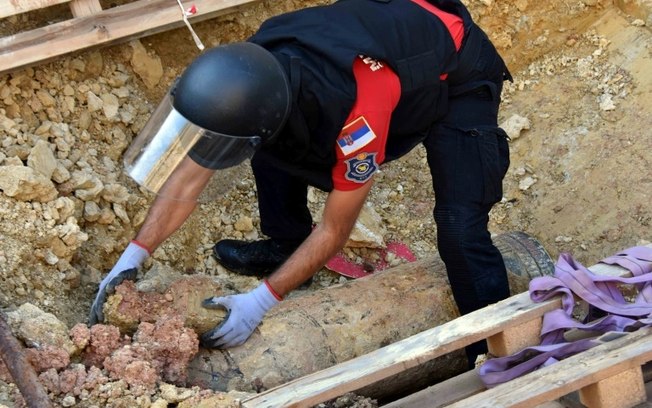 Membro da unidade especial da polícia junto de um obus de artilharia de 300 quilos da Primeira Guerra que não explodiu em Belgrado em uma foto divulgada em 22 de setembro de 2024 pelo Ministério do Interior sérvio