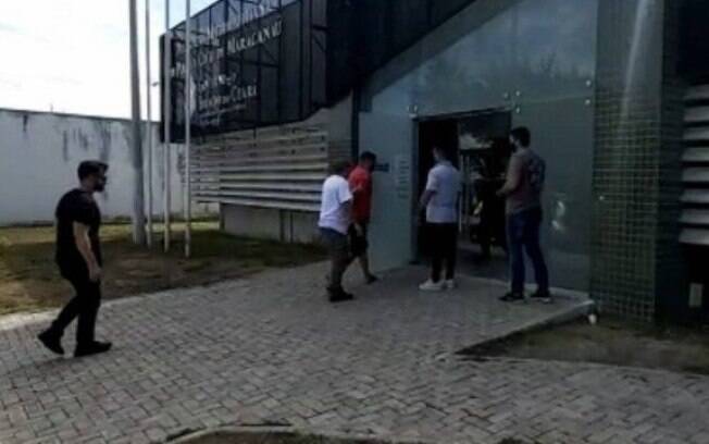 O preso, de camisa laranja, chega a uma unidade policial em Fortaleza.