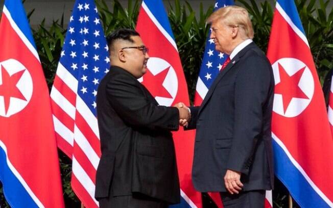 Donald Trump e Kim Jong-un se apertam as mãos antes da reunião histórica
