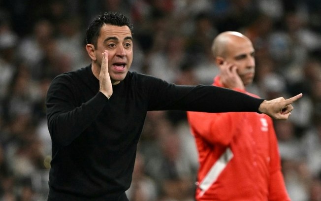 O técnico do Barcelona Xavi Hernández dá instruções aos seus jogadores durante o jogo de LaLiga contra o Real Madrid, no Santiago Bernabéu, no dia 21 de abril de 2024