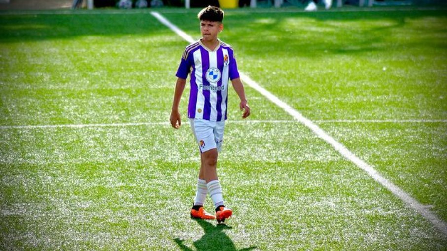 2 jogadores de futebol um deles carrega a bola