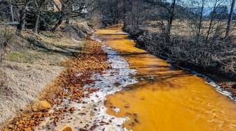 Rio fica laranja após receber água poluída de mina de ferro