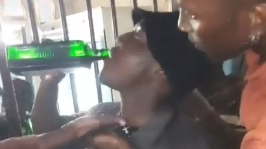 Moment in which the man ingests the entire contents of the liquor bottle, shortly before passing out and passing away