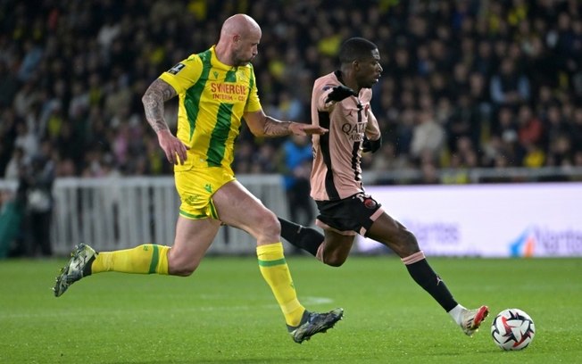 O atacante Ousmane Dembele (à direita) do Paris Saint-Germain e o zagueiro Nicolas Pallois (à esquerda) do Nantes disputam a bola durante a partida da Ligue 1 no Stade de la Beaujoire–Louis Fonteneau em Nantes, em 22 de abril de 2025. O atacante Ousmane Dembele (à direita) do Paris Saint-Germain e o zagueiro Nicolas Pallois (à esquerda) do Nantes disputam a bola durante a partida da Ligue 1 no Stade de la Beaujoire–Louis Fonteneau em Nantes, em 22 de abril de 2025.