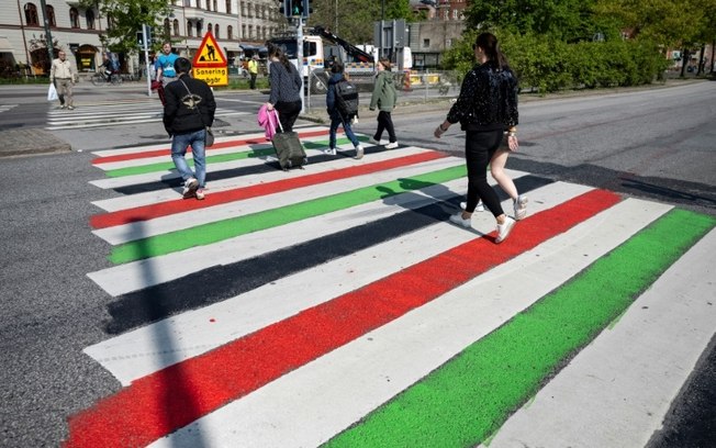 Pessoas cruzam uma faixa de pedestres pintada com as cores da bandeira palestina, em Malmo, na Suécia, em 9 de maio de 2024