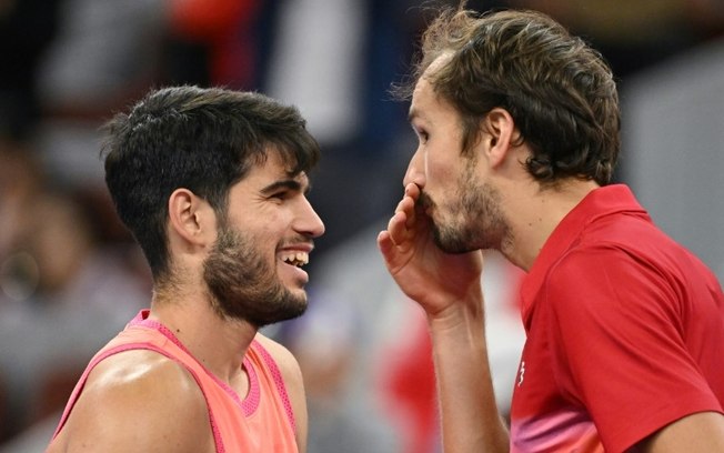 Carlos Alcaraz (E) e Daniil Medvedev (D) conversam na rede após a vitória do espanhol na semifinal do ATP 500 de Pequim