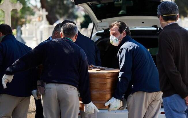 Funcionários de crematório retiram caixão do carro fúnebre; Espanha tem média de 700 mortos por dia