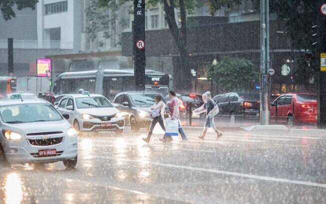 Pedestres atravessam Avenida Paulista durante chuva em São Paulo