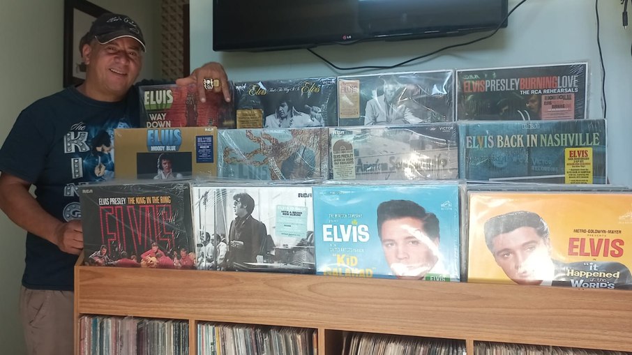 Paulo Bonfim ao lado da coleção de obras de Elvis Presley