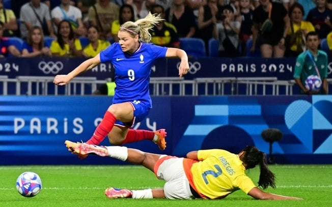 A atacante francesa Eugenie Le Sommer (à esq.) disputa com a zagueira colombiana Manuela Vanegas na estreia das duas seleções no torneio de futebol feminino dos Jogos Olímpicos de Paris-2024, em Lyon, em 25 de julho de 2024.