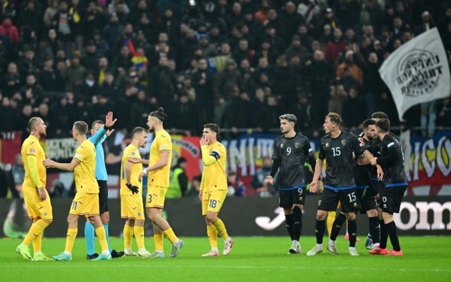 Jogadores da seleção de Kosovo (D) discutem com jogadores da Romênia antes de abandonarem o campo no final do jogo entre as quipes pela Liga das Nações da Uefa