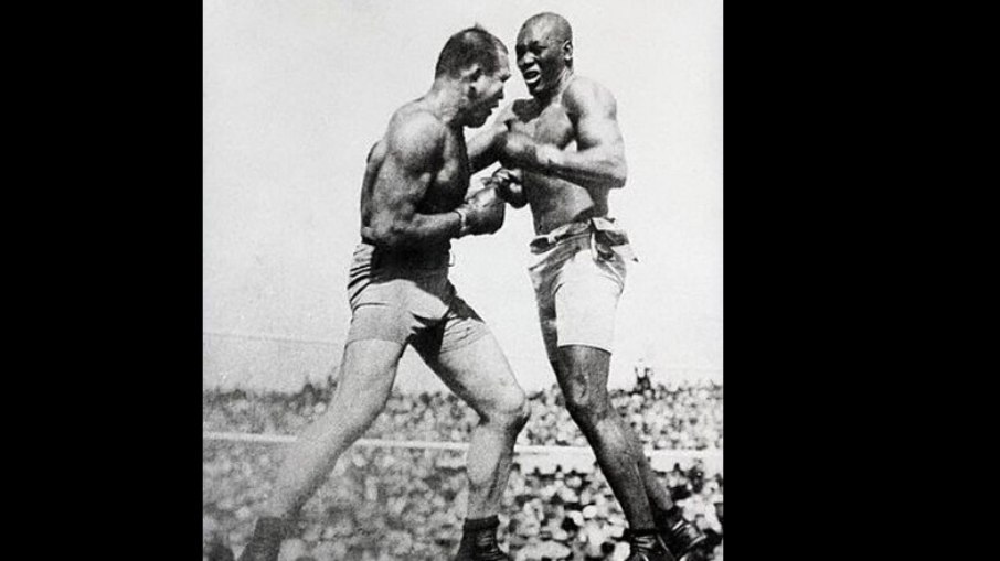 Jack Johnson enfrenta James J. Jeffries em 1910, em um dos combates mais importantes da história do boxe. Jack Johnson enfrenta James J. Jeffries em 1910, em um dos combates mais importantes da história do boxe.