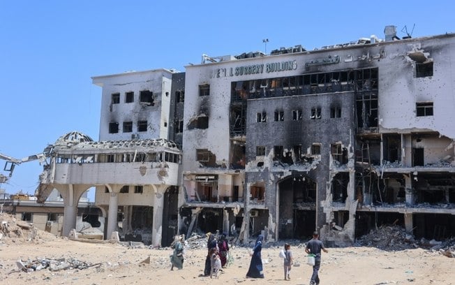 Várias pessoas seguem para um edifício destruído do hospital Al Shifa, em Gaza, em 11 de junho de 2024