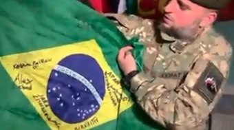 Aliados russos exibem bandeira de brasileiro morto na guerra