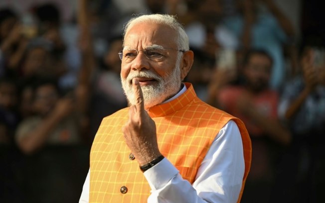 O primeiro-ministro indiano, Narendra Modi, mostra o dedo indicador após votar em Ranip, em 7 de maio de 2024
