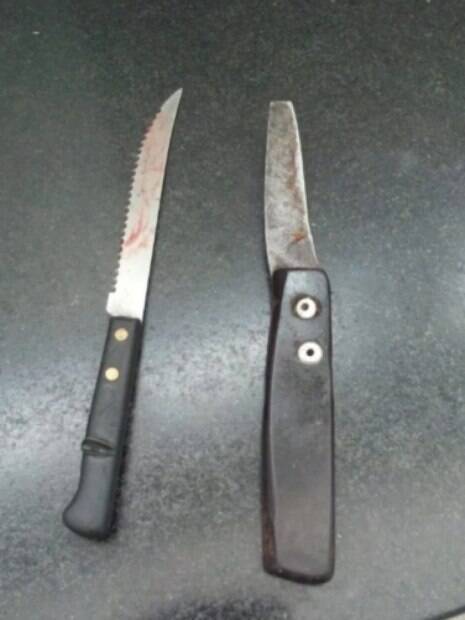duas facas em cima de superfície e sujas de sangue