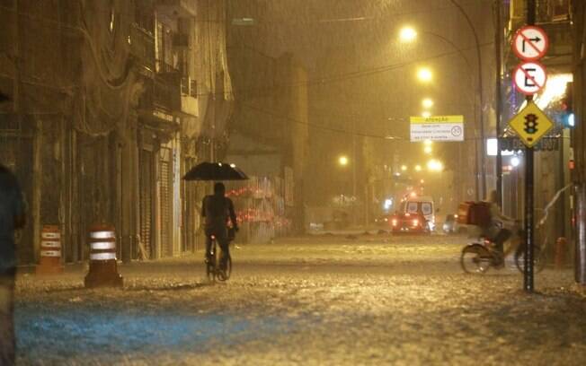 Rua do Senado, no Centro: ciclista adaptou guarda-chuva à bicicleta para minimizar transtorno do temporal