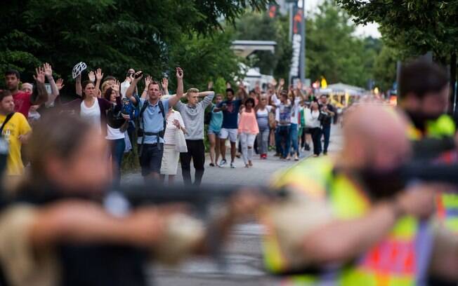 Pessoas levantam os braços após o tiroteio que deixou ao menos dez mortos em Munique, na Alemanha, na sexta