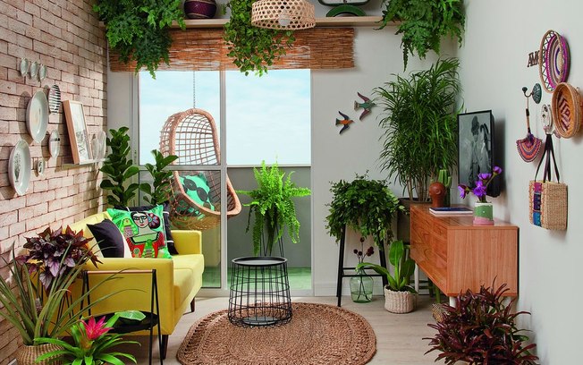 Sala de estar e varanda com inspiração urban jungle tem tijolinhos e horta