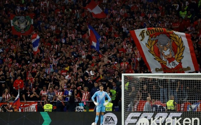 O goleiro do Real Madrid, Thibaut Courtois, espera após torcedores do Atlético atirarem objetos no campo durante jogo pelo Campeonato Espanhol