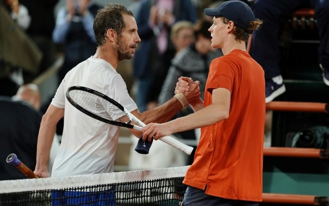 Jannik Sinner (à dir.) é cumprimentado por Richard Gasquet (à esq.) após derrotá-lo na segunda rodada em Roland Garros em Paris, no dia 29 de maio de 2024