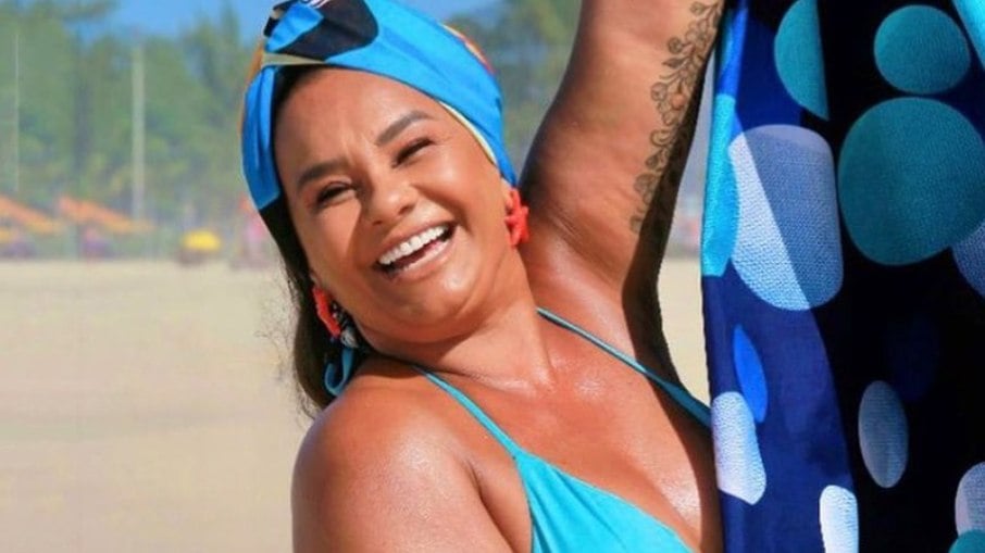 Solange Couto posando de biquíni azul na praia