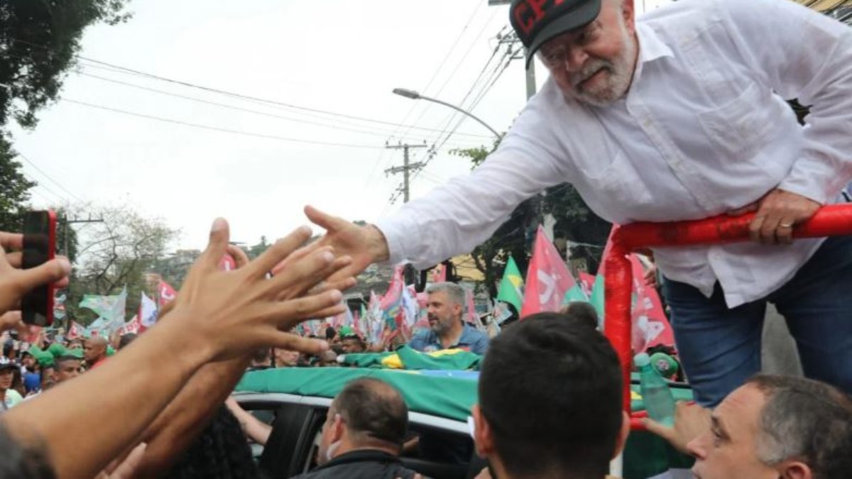 Lula usando o boné com a sigla 'CPX' durante evento de campanha no Complexo do Alemão 