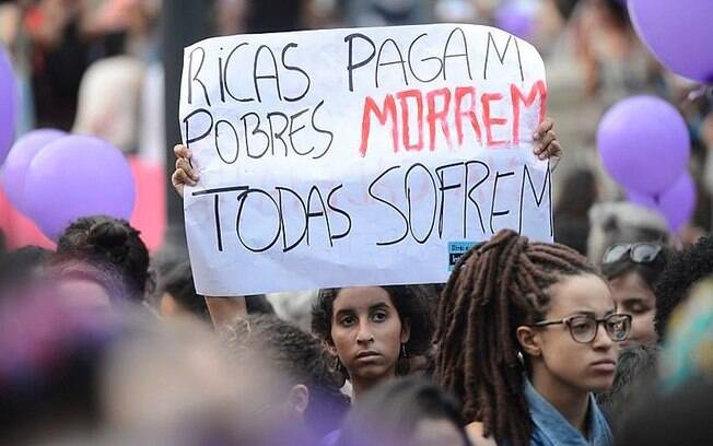 mulher segurando cartaz em manifestação