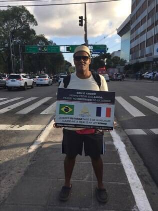 André Sena segurando um cartaz no semáforo