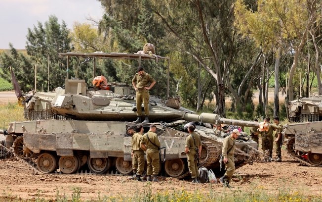 Soldados israelenses em torno de tanques em uma área próxima à Faixa de Gaza, sul de Israel, em 10 de abril de 2024