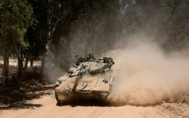 Um tanque israelense passa por uma área ao longo da fronteira sul de Israel com a Faixa de Gaza, em 2 de junho de 2024