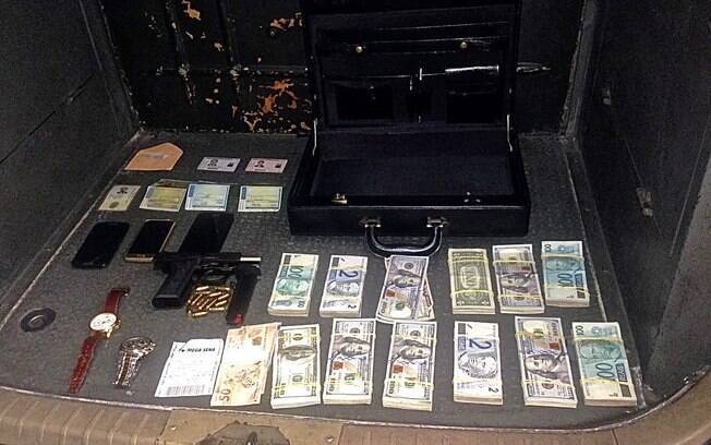11 mil Dólares, Reais, pistola e munição, celulares, documentos, relógios e o bilhete falso da Mega-Sena