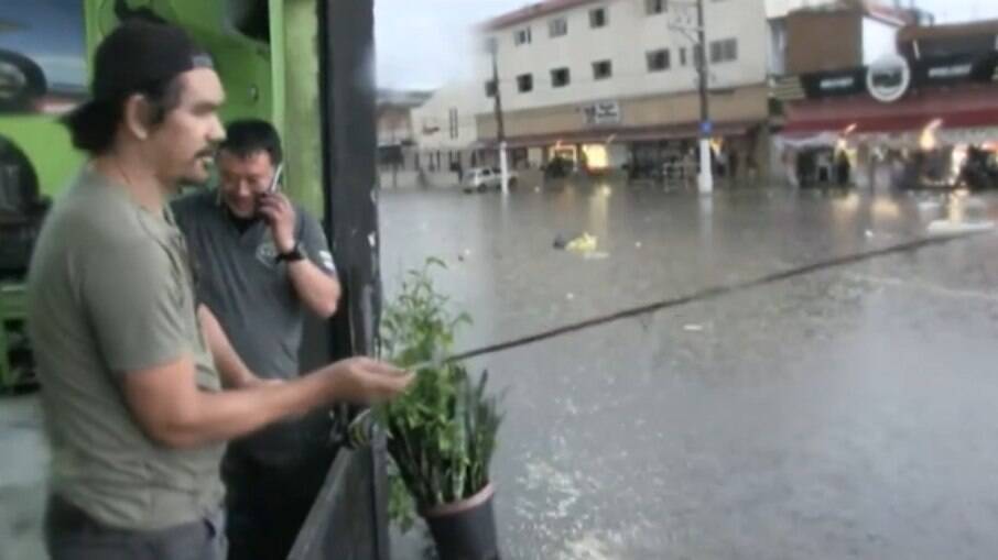 Homem pescando na enchente em SP