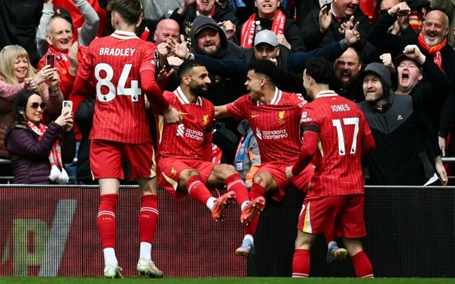 O atacante egípcio do Liverpool, Mohamed Salah (2º à esq.) e o colombiano Luis Diaz (2º à dir.) comemoram o gol deste último no jogo da Premier League contra o West Ham em 13 de abril de 2025 no estádio de Anfield, em Liverpool. O atacante egípcio do Liverpool, Mohamed Salah (2º à esq.) e o colombiano Luis Diaz (2º à dir.) comemoram o gol deste último no jogo da Premier League contra o West Ham em 13 de abril de 2025 no estádio de Anfield, em Liverpool.