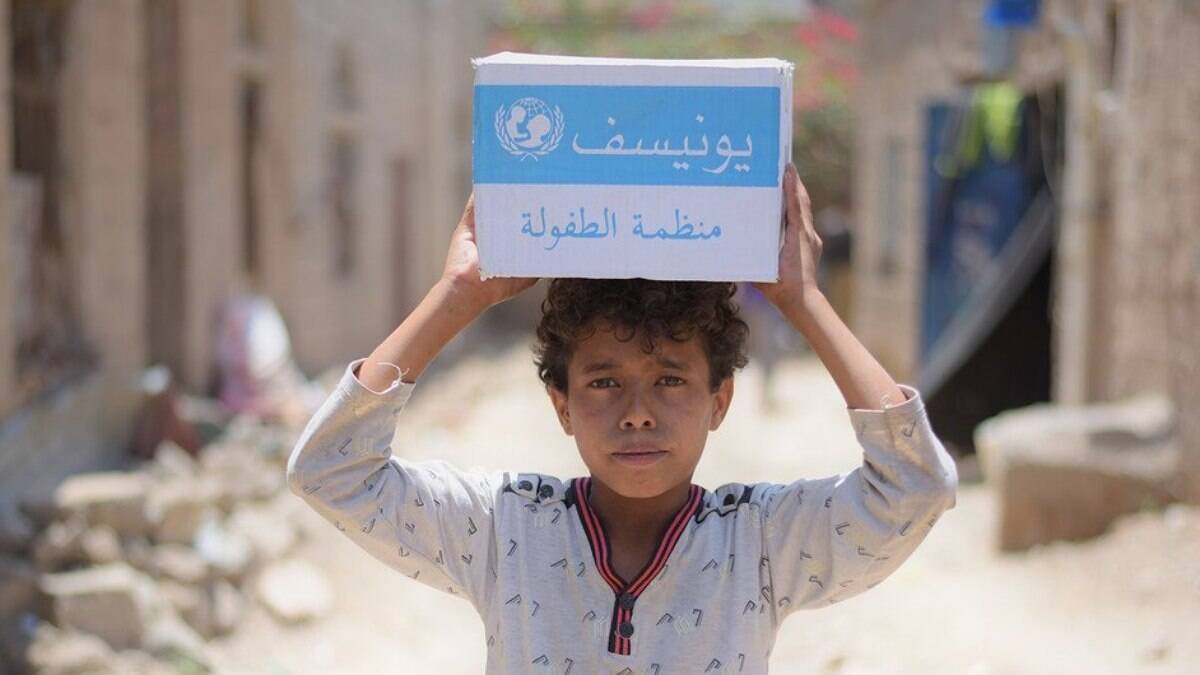 Menino carrega caixa de sabão fornecida pela ONU