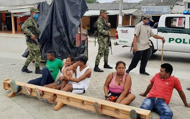 Pessoas que desrespeitaram as normas de isolamento social foram detidas pela polícia local e presas pelos pés