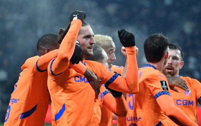 O meio-campista do Olympique de Marselha, Adrien Rabiot, comemora com seus companheiros o primeiro gol contra o Angers na 21ª rodada da Ligue 1, no estádio Raymond-Kopa em Angers, oeste da França, em 9 de fevereiro de 2025