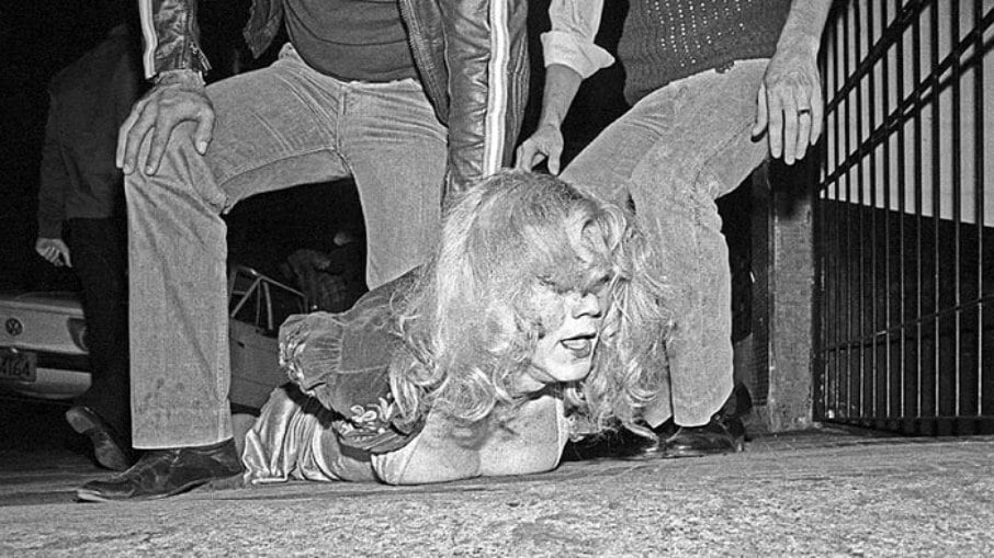 Mulher trans sendo presa em uma das operações policiais contra a população trans e travestis dos anos de 1980
