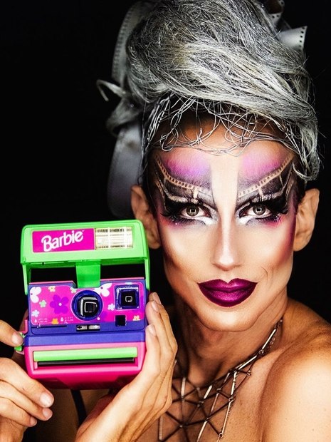 drag queen segurando câmera polaroid