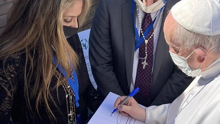 Papa aprova projeto do próximo Papamóvel da Fisker assinando o esboço.