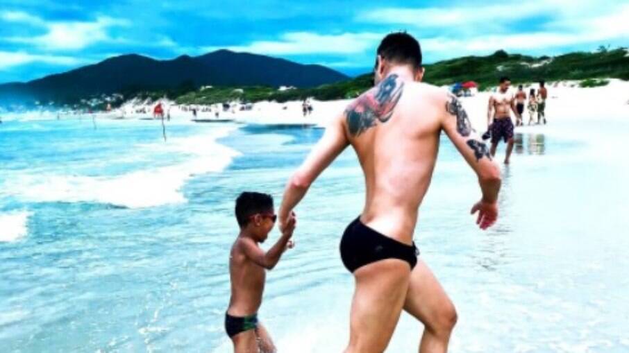 Bruno Nascimento, a drag queen Aretuza Lovi, com o filho na praia