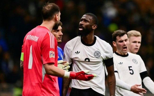 Antonio Rüdiger (centro) discute com o goleiro italiano Gianluigi Donnarumma durante a primeira partida das quartas de final da Liga das Nações, em 20 de março de 2025, no estádio de San Siro, em Milão. Antonio Rüdiger (centro) discute com o goleiro italiano Gianluigi Donnarumma durante a primeira partida das quartas de final da Liga das Nações, em 20 de março de 2025, no estádio de San Siro, em Milão.