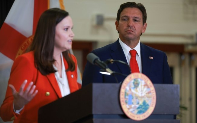 O governador da Flórida, Ron DeSantis, ouve a procuradora-geral do estado, Ashley Moody