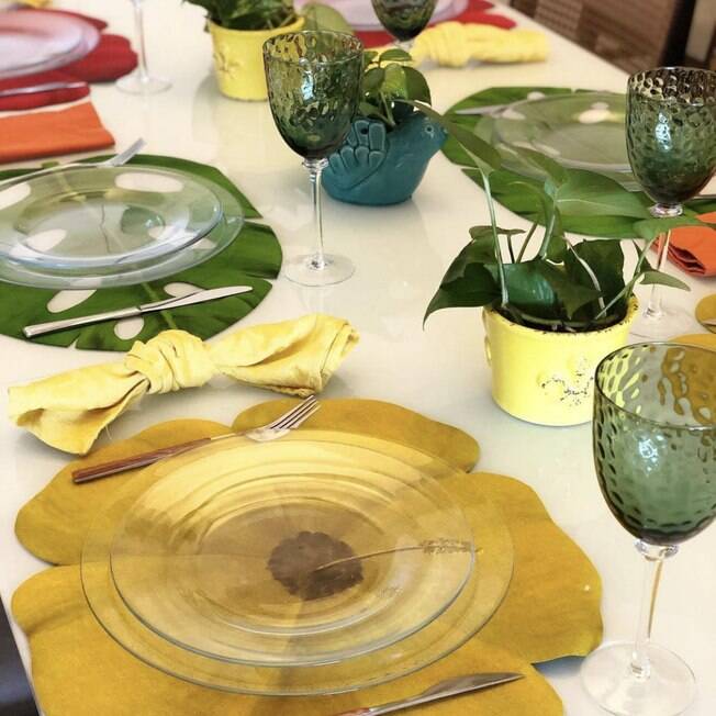 O uso de pratos em vidro na composição da mesa destaca os jogos americanos
