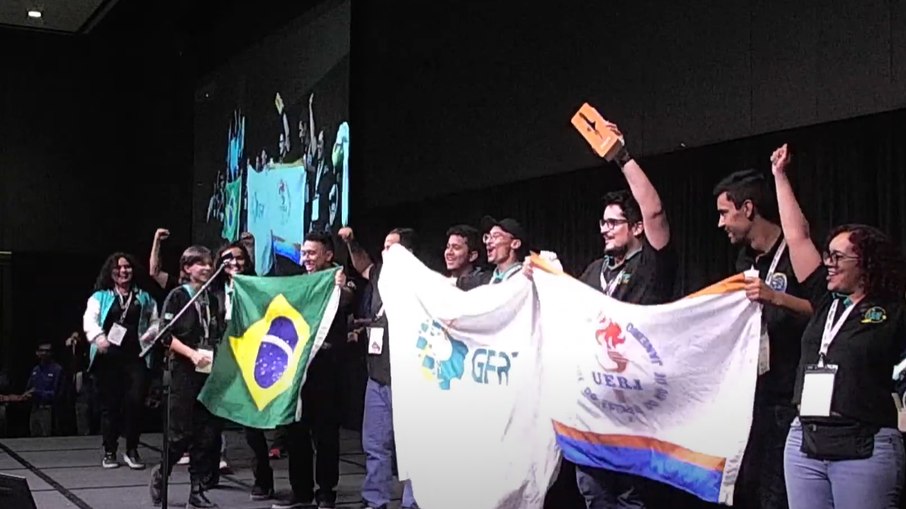 Equipe GFRJ, da UERJ, celebra no palco da IREC 2025 a conquista do Nancy Squires Team Spirit Award, reconhecimento pelo espírito de equipe e entusiasmo ao longo da competição. Equipe GFRJ, da UERJ, celebra no palco da IREC 2025 a conquista do Nancy Squires Team Spirit Award, reconhecimento pelo espírito de equipe e entusiasmo ao longo da competição.